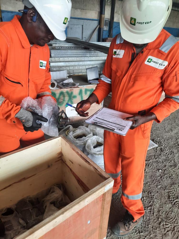 Kaizen Global staff in company coveralls reviewing job documentation on site